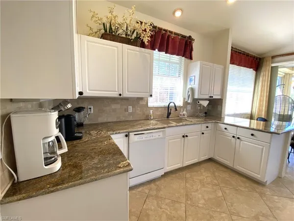 a kitchen with a sink window and cabinets