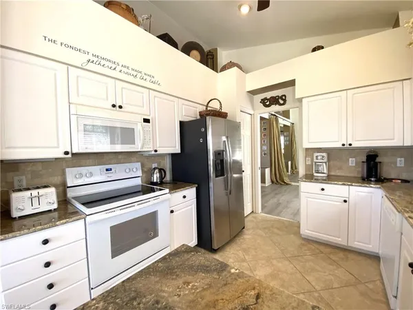 a kitchen with white cabinets and white appliances