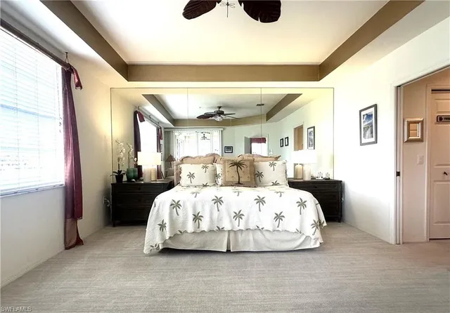 a large bed sitting in a bedroom next to a window and a chandelier