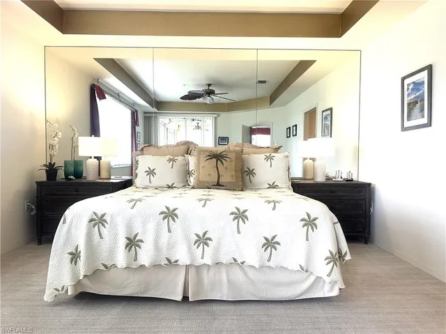 a bedroom with a bed and a large mirror