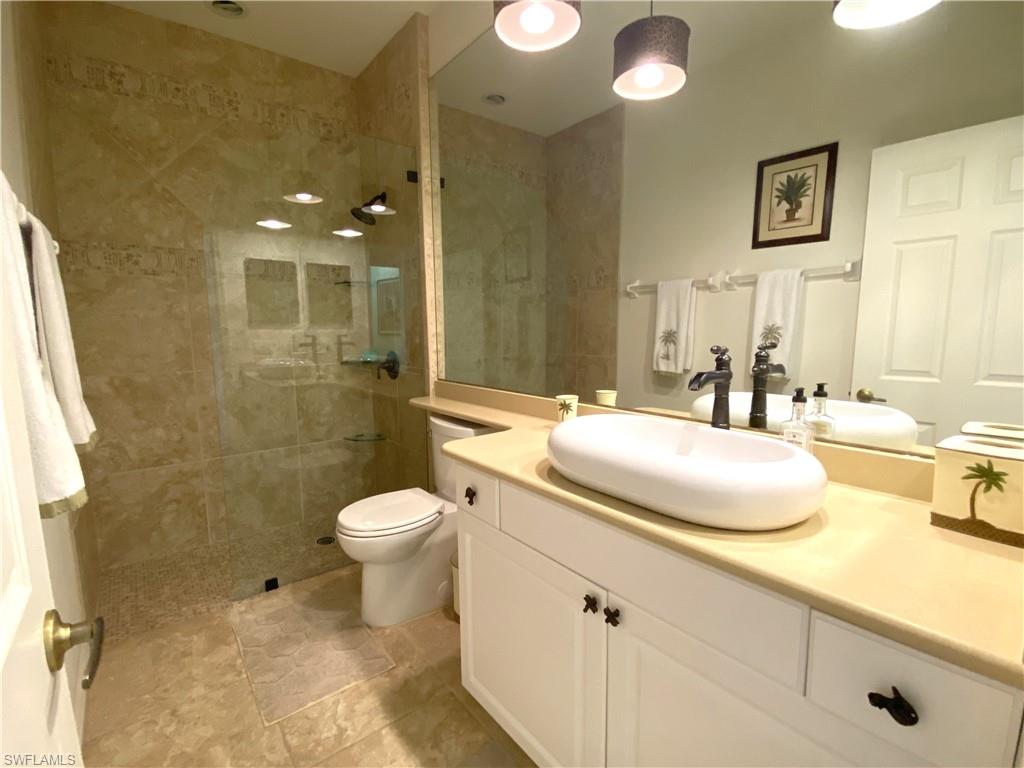 1570 Winding Oaks Way, Unit 201 Naples, FL 34109 - Photo 28 of 35 a bathroom with a sink toilet and shower