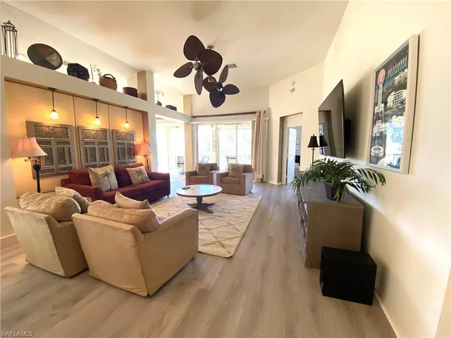 a living room with furniture wooden floor and a large window