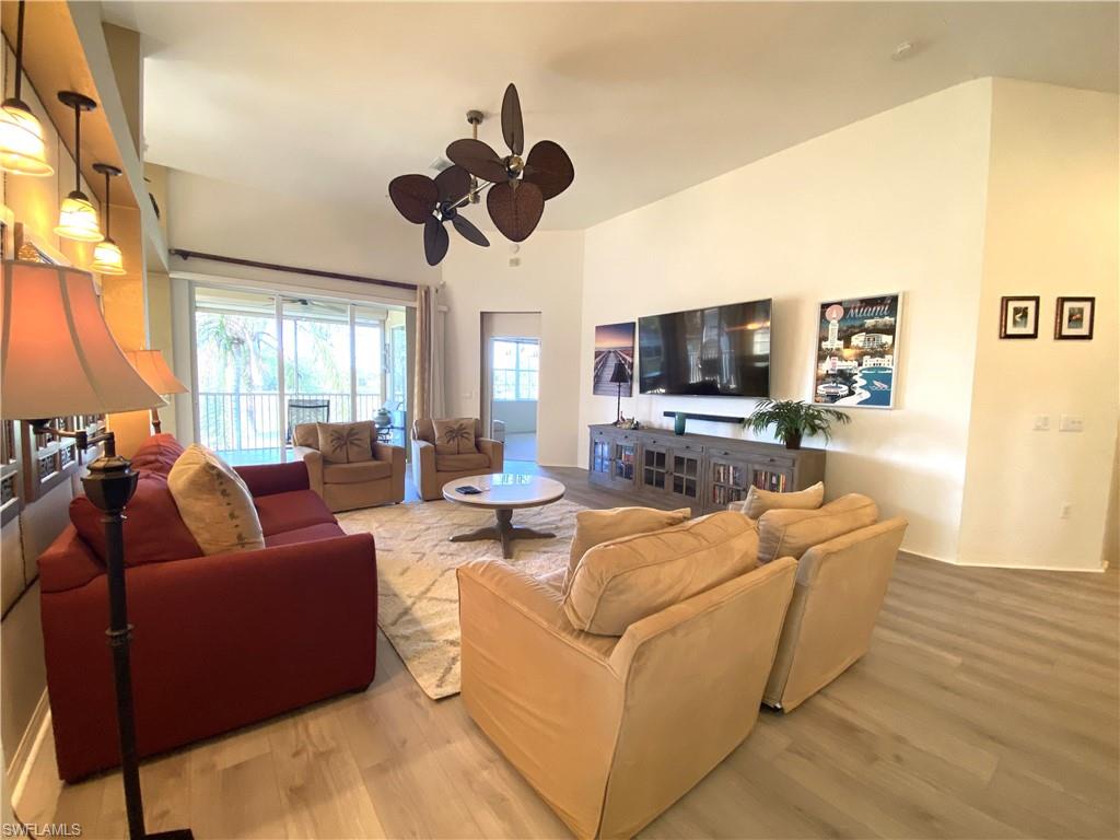 1570 Winding Oaks Way, Unit 201 Naples, FL 34109 - Photo 8 of 35 a living room with furniture a flat screen tv and a large window