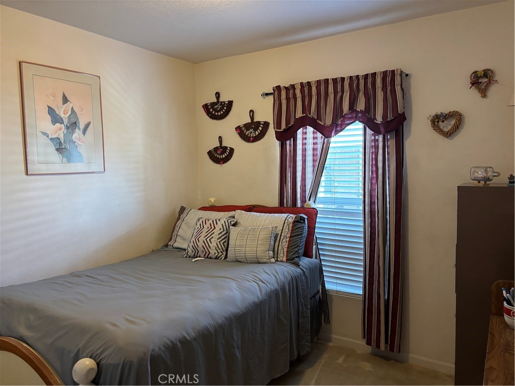 8389 Baker Avenue, Unit 82 Rancho Cucamonga, CA 91730 - Photo 7 of 13 a bedroom with a bed and a painting on the wall