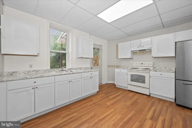 a kitchen with white cabinets and white appliances