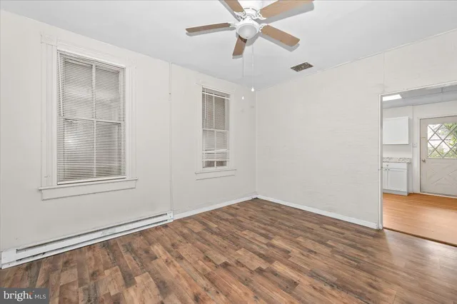 a view of empty room with wooden floor