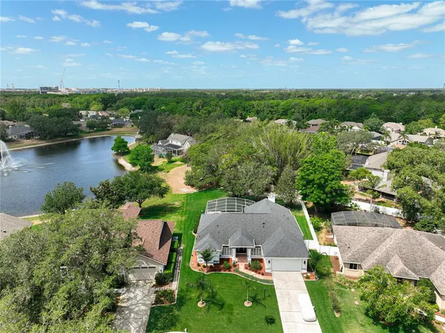 an aerial view of a house with a garden and lake view