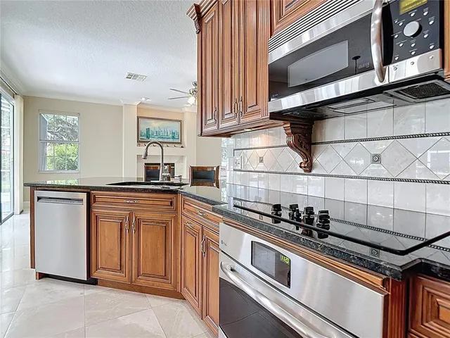 a large kitchen with granite countertop a stove a sink a window and dining table