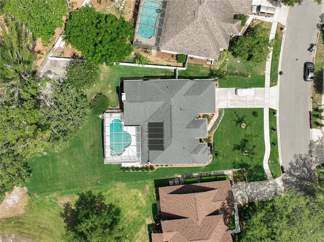 an aerial view of residential houses with outdoor space and trees