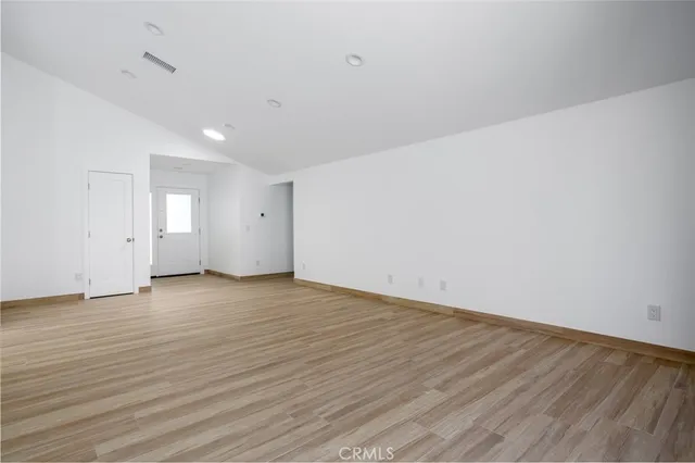 a view of an empty room and wooden floor