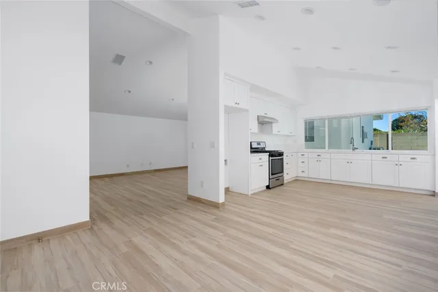 a view of a kitchen with wooden floor and electronic appliances