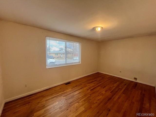 8950 Ithaca Way Westminster, CO 80031 - Photo 5 of 13 an empty room with wooden floor and windows
