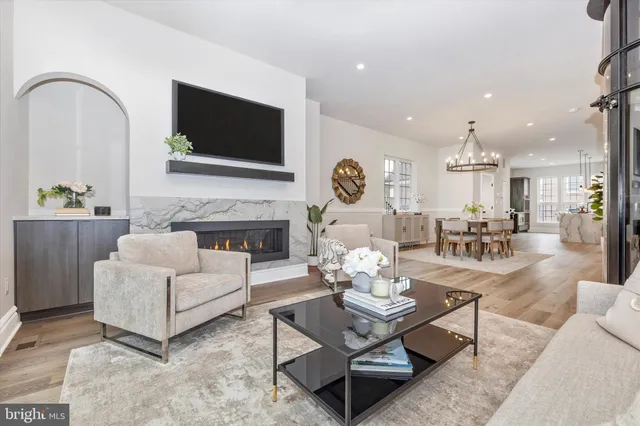 a dining room with wooden floor a chandelier a wooden table and chairs