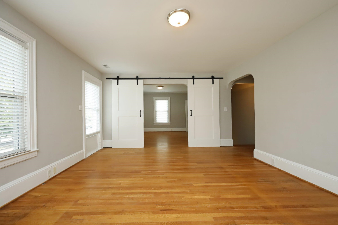 Undisclosed Address Raleigh, NC 27605 - Photo 27 of 38 a view of an empty room with window and wooden floor