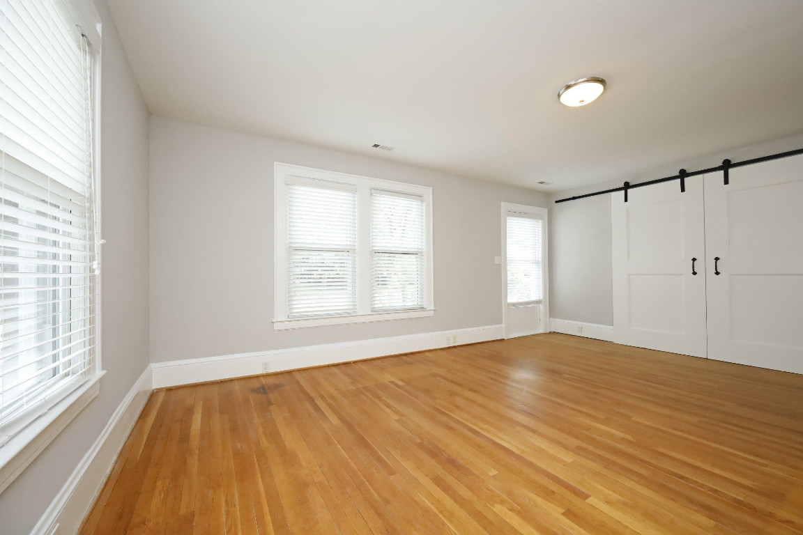 Undisclosed Address Raleigh, NC 27605 - Photo 30 of 38 an empty room with wooden floor and windows