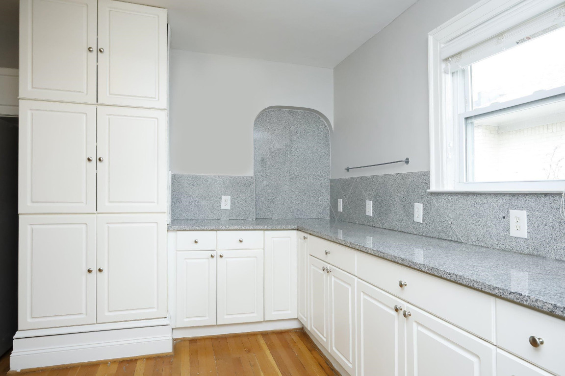 Undisclosed Address Raleigh, NC 27605 - Photo 6 of 38 a kitchen with granite countertop white cabinets and white appliances