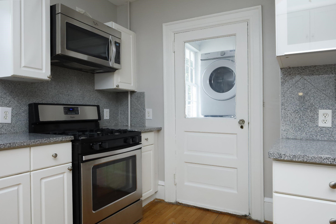 Undisclosed Address Raleigh, NC 27605 - Photo 10 of 38 a kitchen with white cabinets and stainless steel appliances