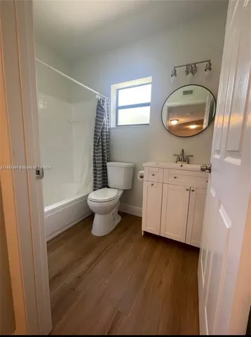 a spacious bathroom with a toilet a sink and a mirror