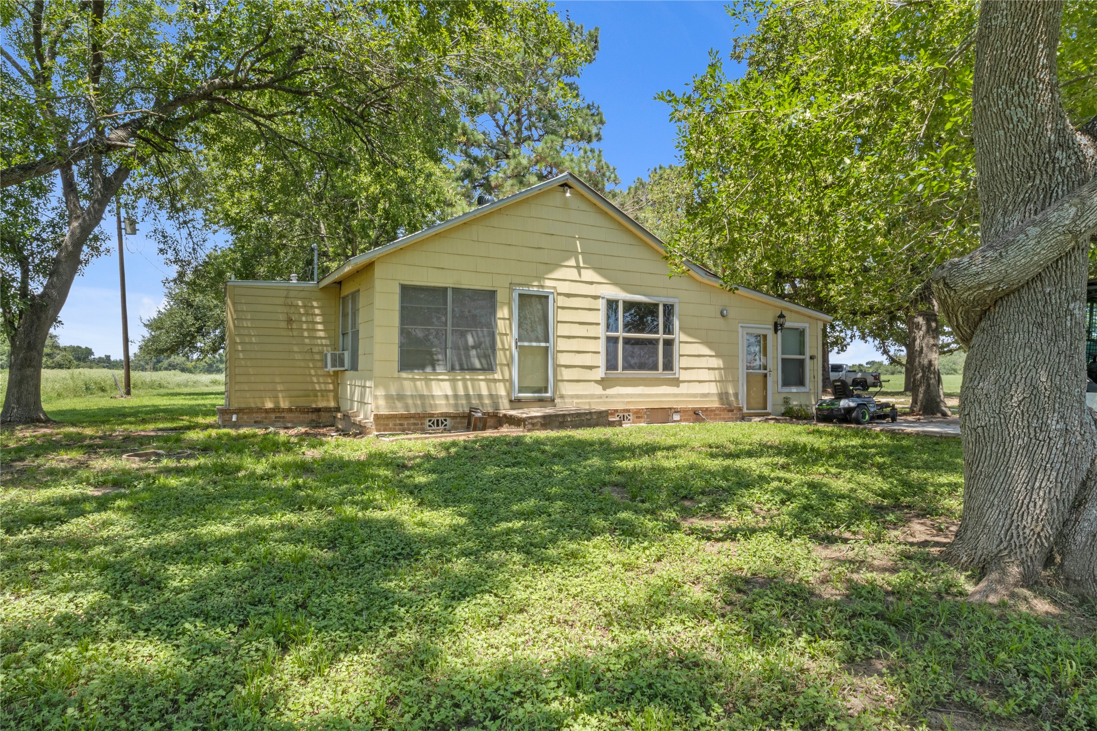451 Pleasant Grove Road Elgin, TX 78621 - Photo 3 of 32 a view of a yard in front of a house with large trees