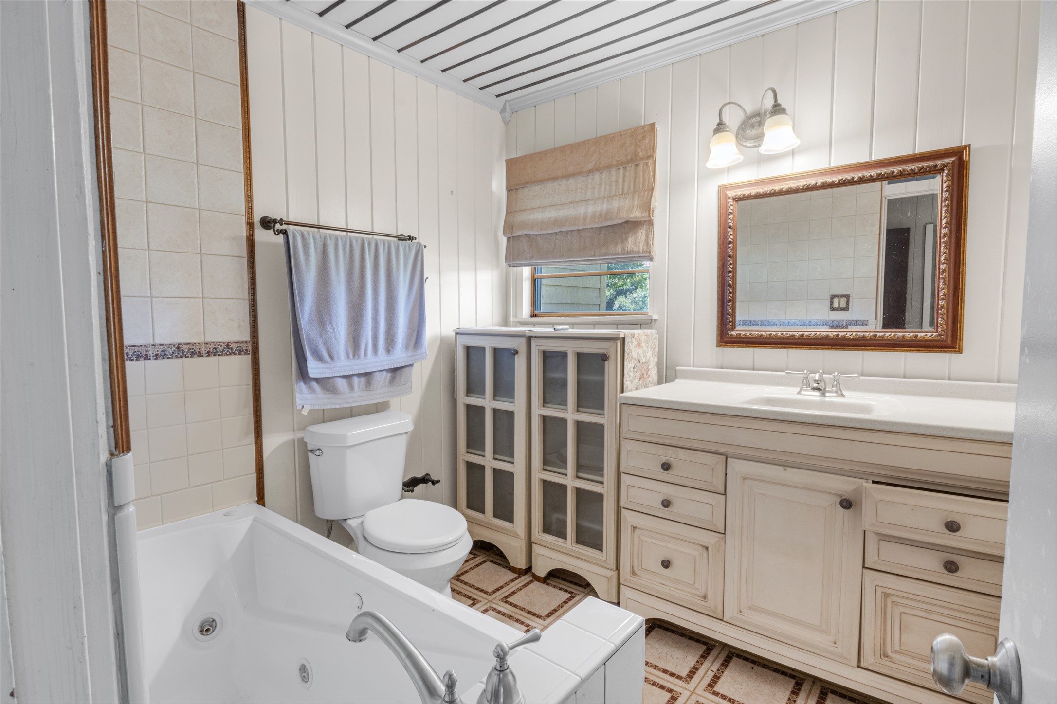 451 Pleasant Grove Road Elgin, TX 78621 - Photo 10 of 32 a bathroom with a sink toilet a mirror and bathtub