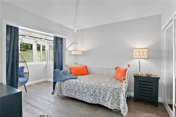 a bedroom with two beds and wooden floor