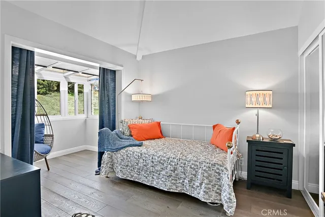 a bedroom with two beds and wooden floor