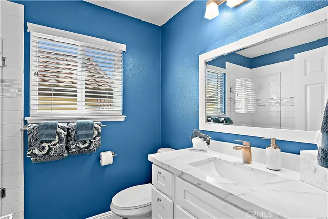 a bathroom with a sink a toilet and a window