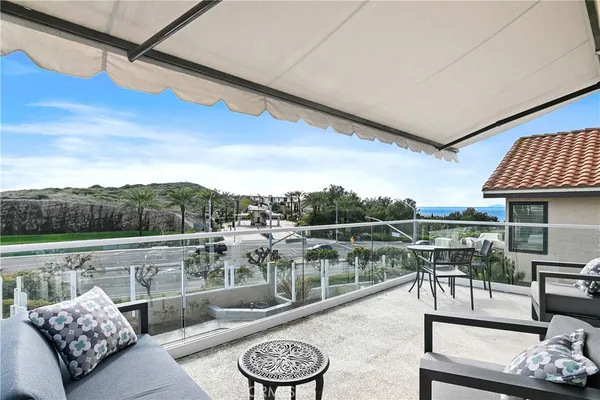 a view of a balcony with furniture and a floor to ceiling window
