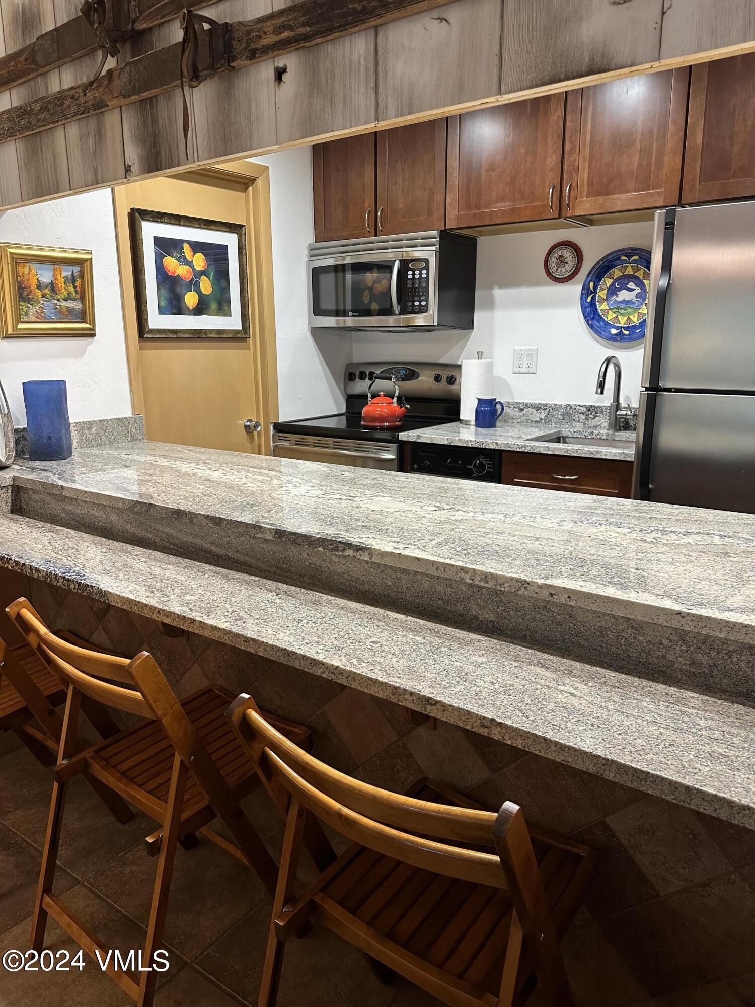 595 Vail Valley Drive, Unit E121 Vail, CO 81657 - Photo 7 of 12 a view of kitchen with stainless steel appliances granite countertop a refrigerator and a stove top oven