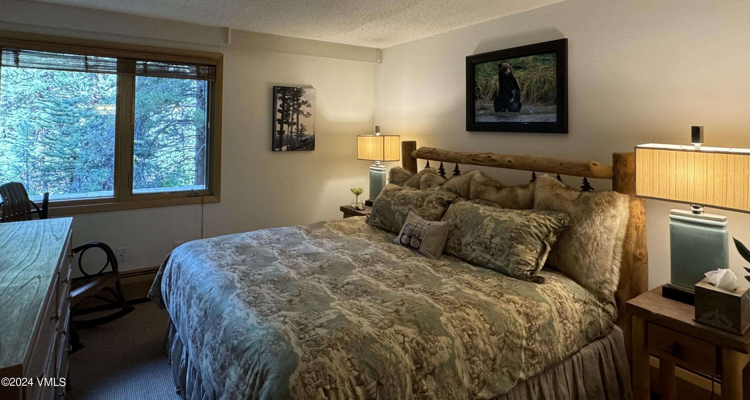 595 Vail Valley Drive, Unit E121 Vail, CO 81657 - Photo 8 of 12 a bedroom with a bed and dresser next to a window