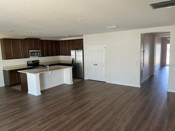 a kitchen with stainless steel appliances kitchen island a cabinets and wooden floor