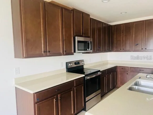 a kitchen with stainless steel appliances a stove microwave and cabinets
