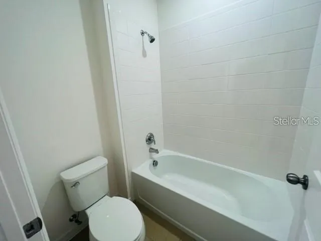 a white toilet and tub sitting next to a bathroom sink