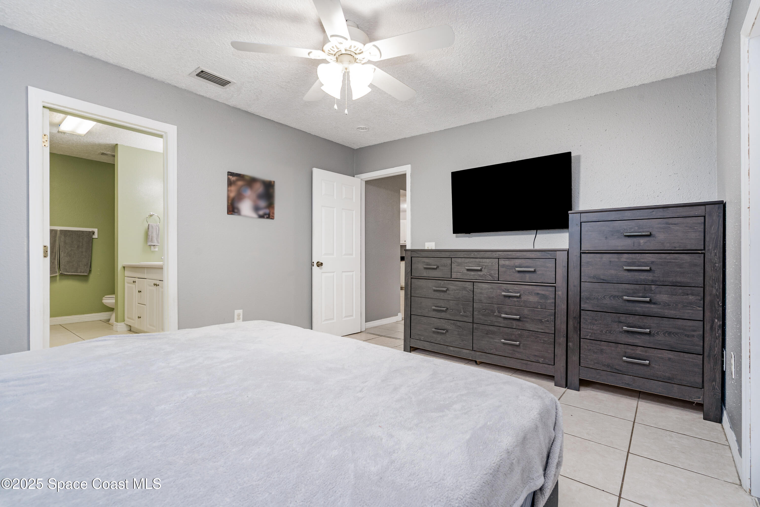4120 Duke Street Melbourne, FL 32901 - Photo 14 of 29 a bedroom with a bed and a flat screen tv