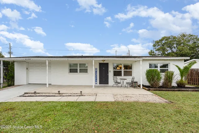 a front view of a house with a garden and yard