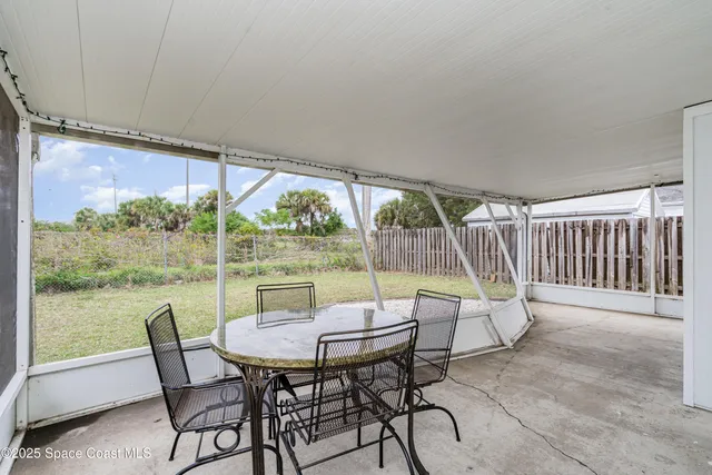 a view of a patio with a table chairs and a backyard