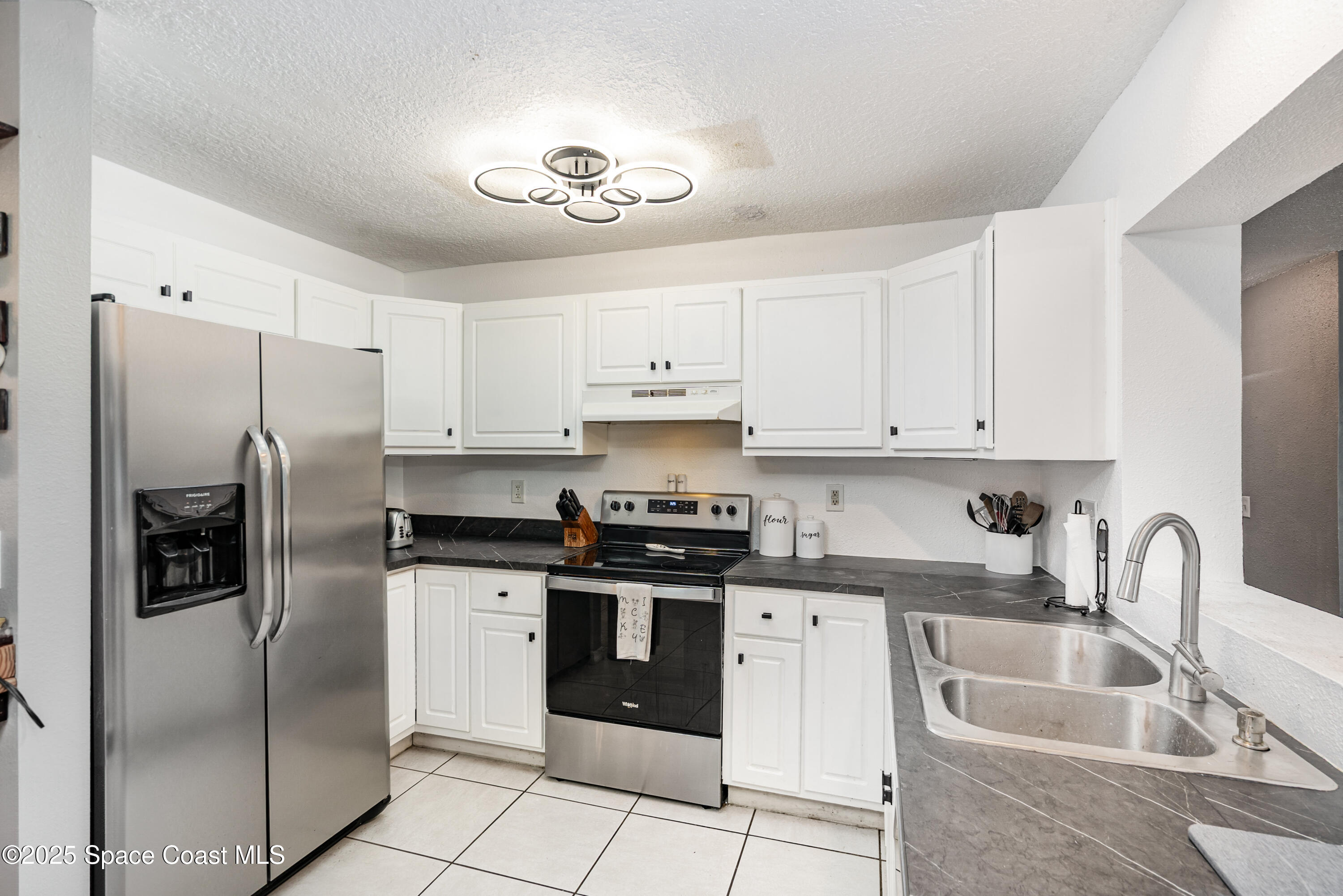 4120 Duke Street Melbourne, FL 32901 - Photo 8 of 29 a kitchen with stainless steel appliances granite countertop a refrigerator sink and cabinets