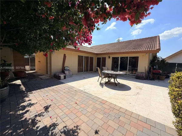 a backyard of a house with table and chairs
