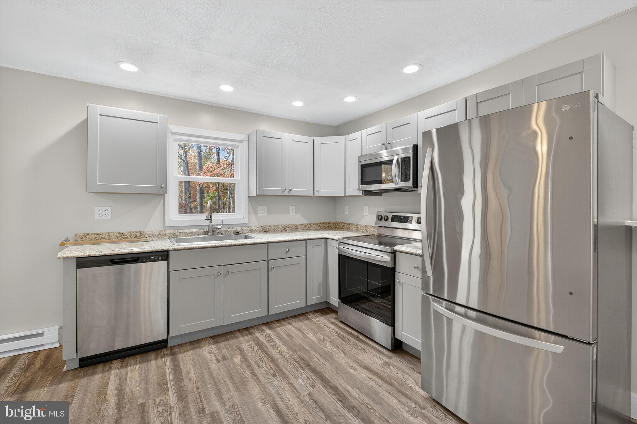 19239 Mountain Track Road Orange, VA 22960 - Photo 8 of 19 a kitchen with granite countertop stainless steel appliances a refrigerator sink and microwave
