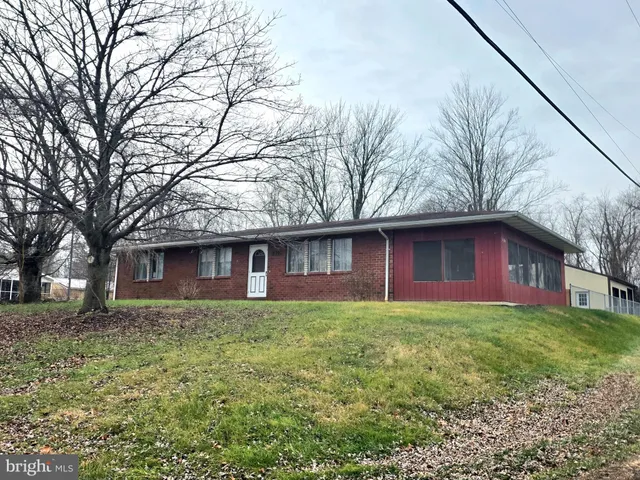 a brick house with trees in front of it
