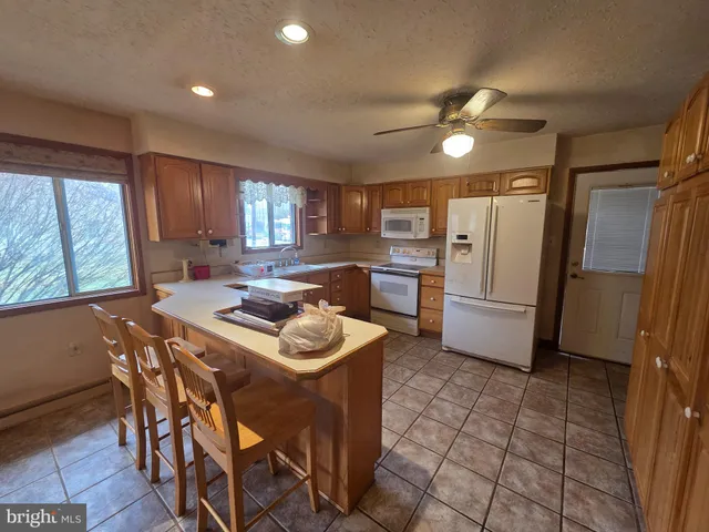 a living room with stainless steel appliances kitchen island granite countertop furniture and a refrigerator