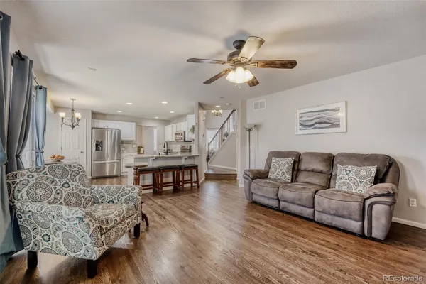 a living room with furniture and a wooden floor