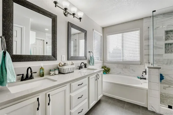 a bathroom with a granite countertop sink mirror and bathtub