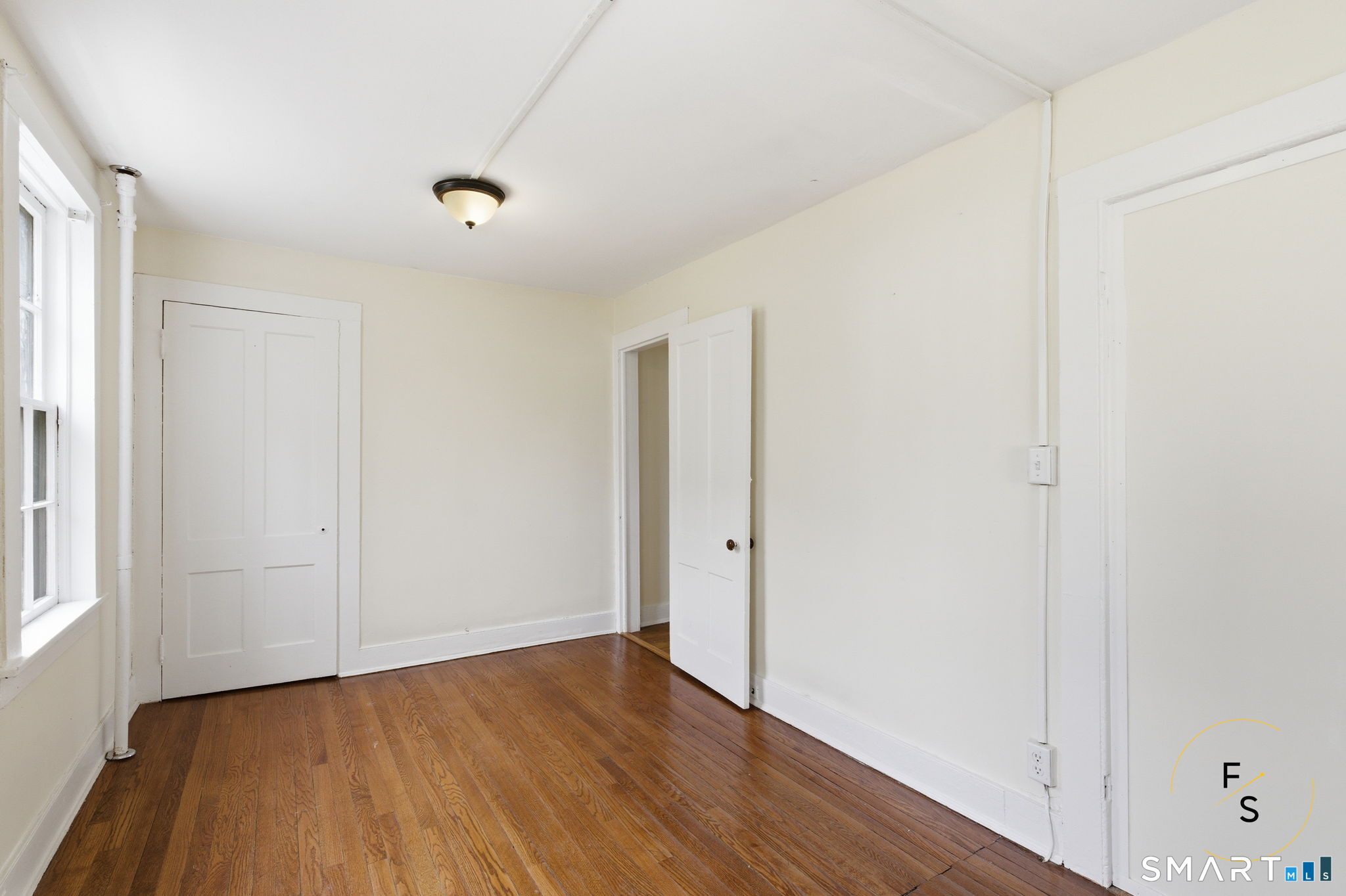 119 Williams Street Norwich, CT 06360 - Photo 14 of 40 an empty room with wooden floor and windows