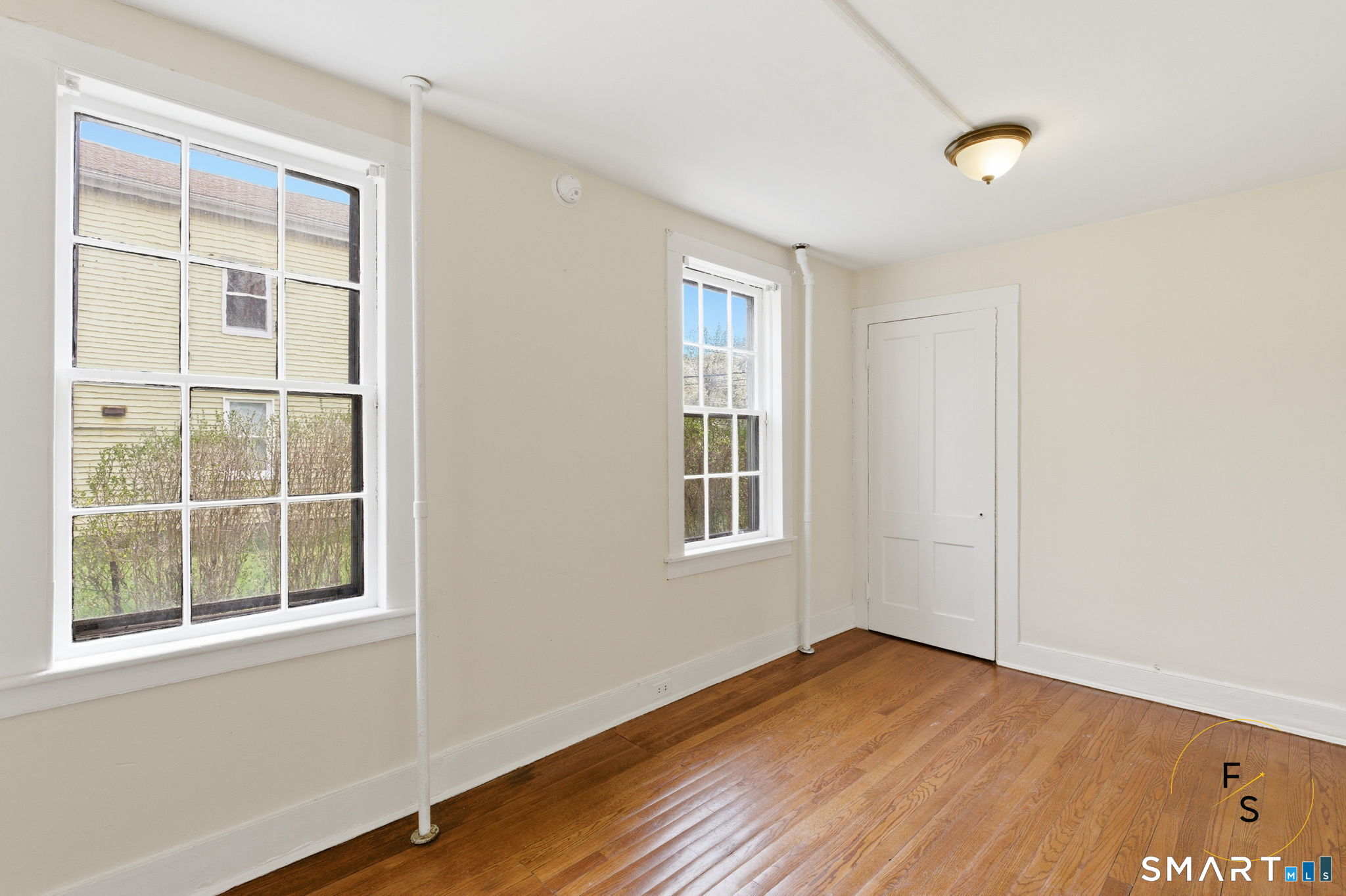 119 Williams Street Norwich, CT 06360 - Photo 15 of 40 an empty room with wooden floor and windows