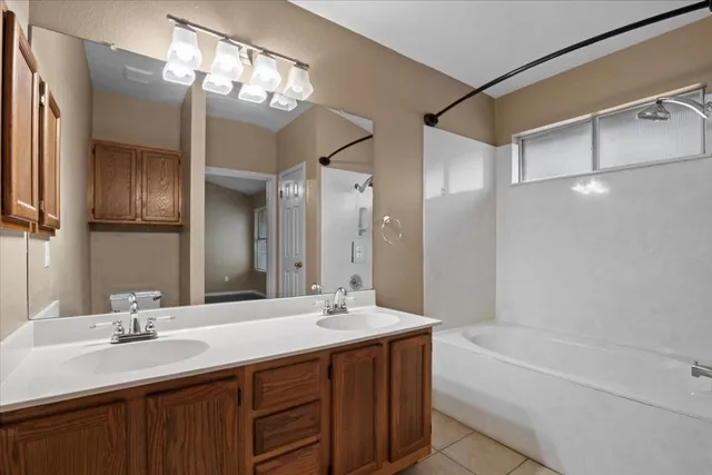 a bathroom with a bathtub double vanity sink and a mirror