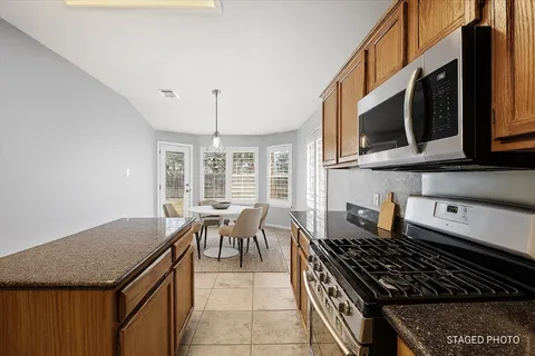 a kitchen with stainless steel appliances granite countertop a stove and a microwave