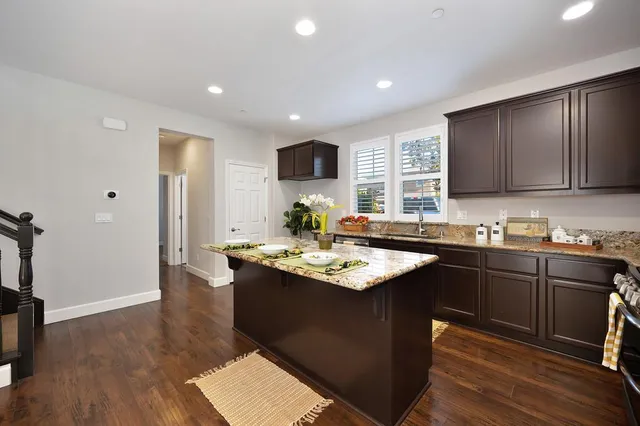 a kitchen with stainless steel appliances granite countertop a sink stove and wooden floor