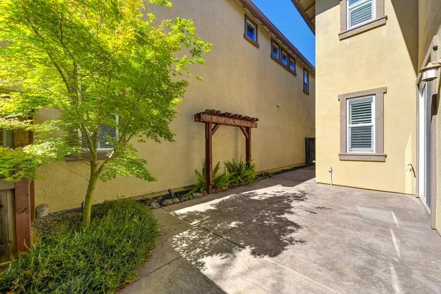 a view of a house with backyard and a tree