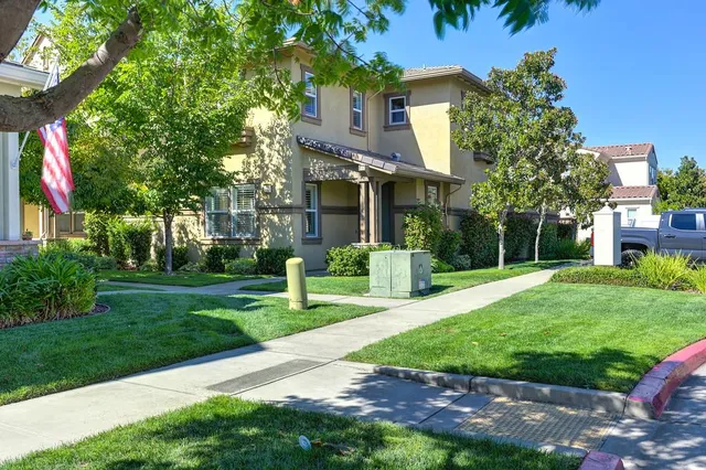 a front view of a house with a yard and tree s